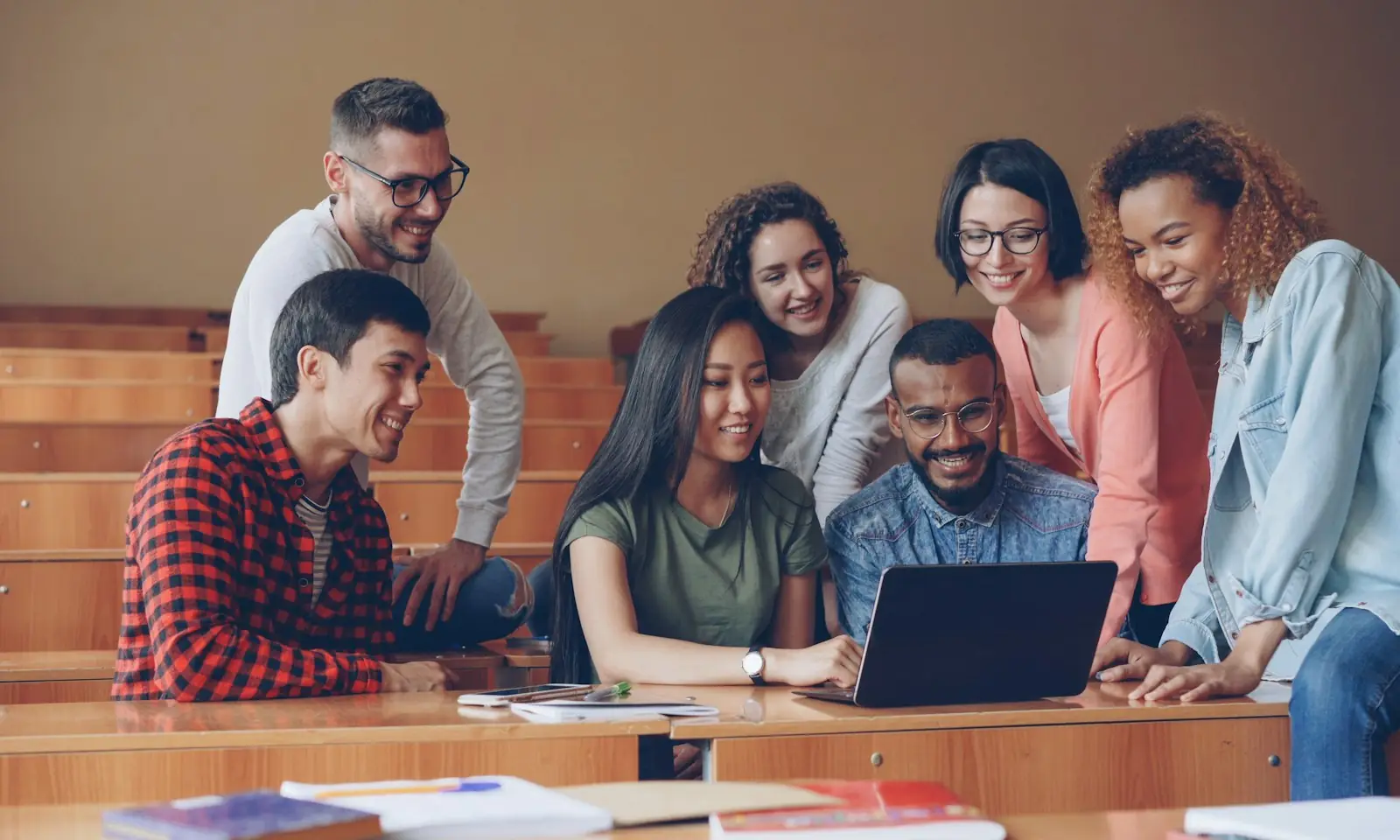 A group of students working together around a laptop